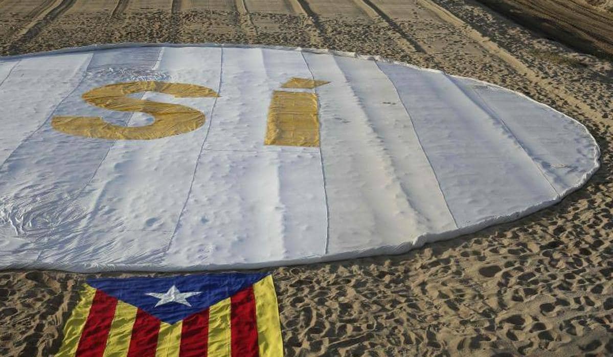 Imagen de una estelada acompañada de un «sí» a la independencia en la playa de Masnou