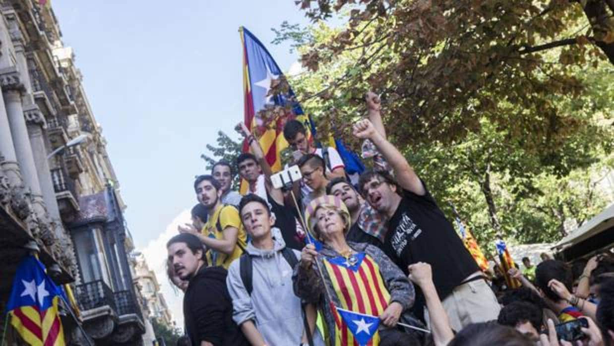Cientos de ciudadanos protestan por los registros del 1-O en la Gran Vía con Rambla Catalunya, en Barcelona, donde se encuentra la consellería de Economía