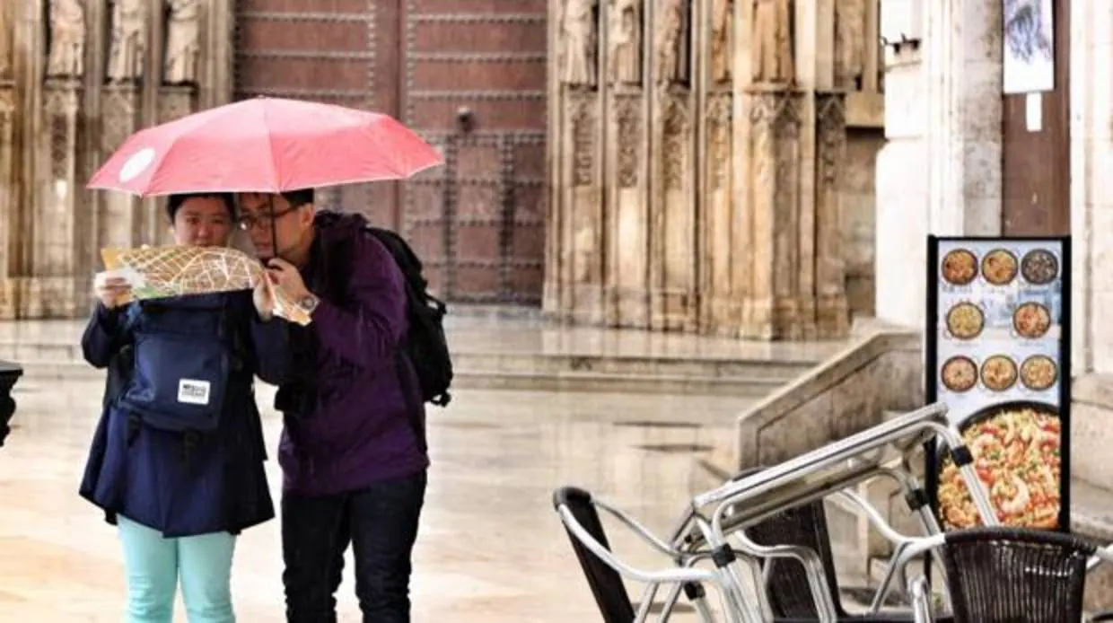 Dos turistas se protegen de la lluvia el pasado otoño en Valencia