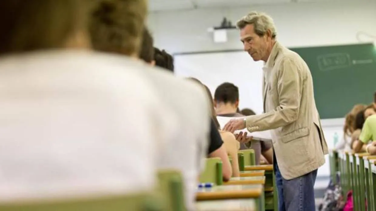 Un docente reparte exámenes a estudiantes de Bachillerato en Valencia