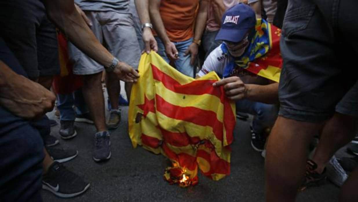 Un grupo de personas quema una estelada independentista, este lunes en Valencia