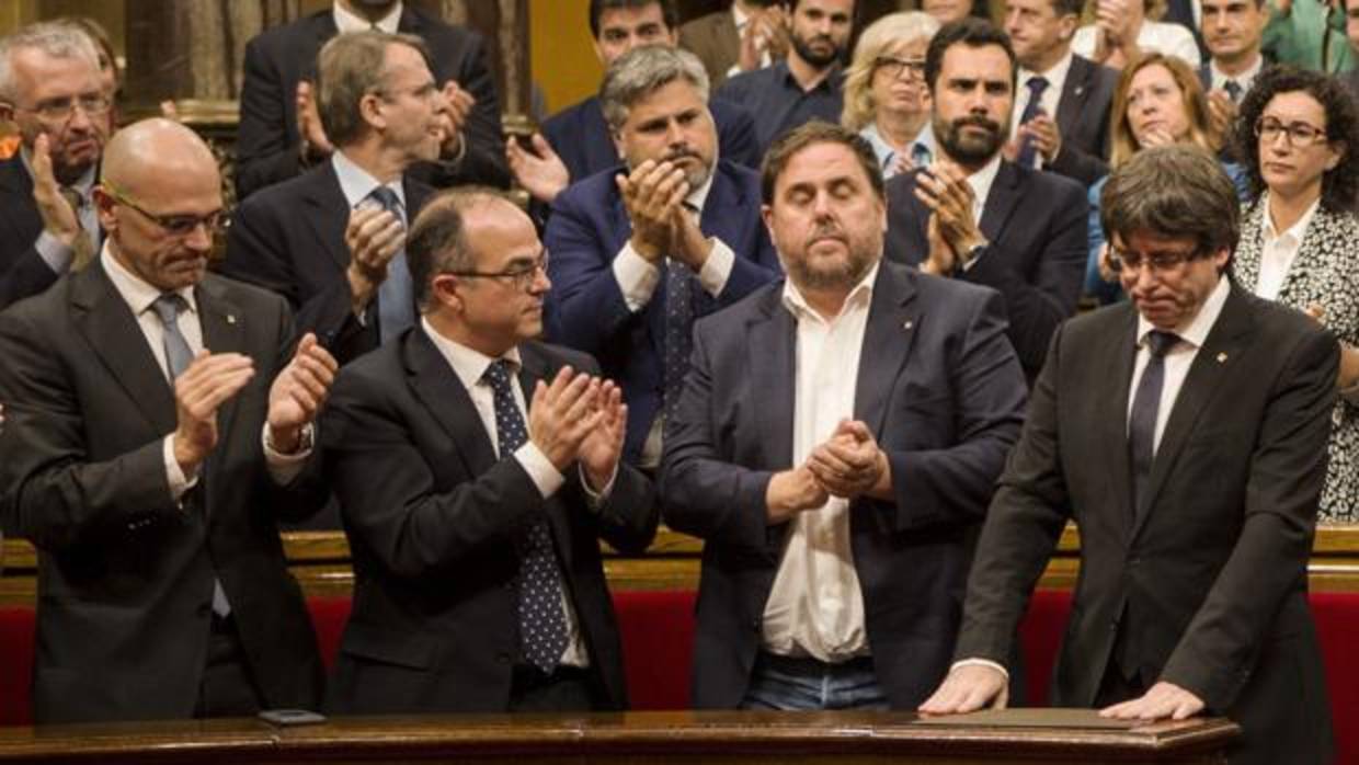 El presidente de la Generalitat, Carles Puigdemont recibe el aplauso de los miembros del del Govern tras su comparecencia el 10 de octubre en el Parlament