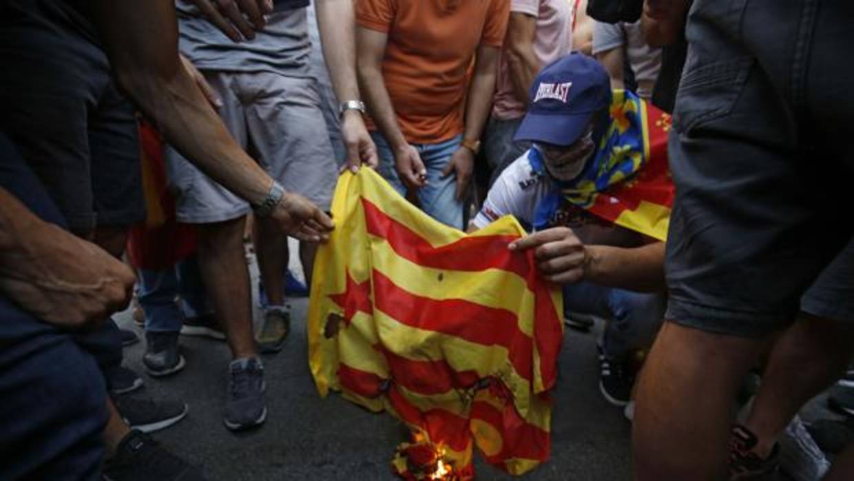 Un grupo de personas quema una bandera independentista el pasado 9 de octubre en Valencia