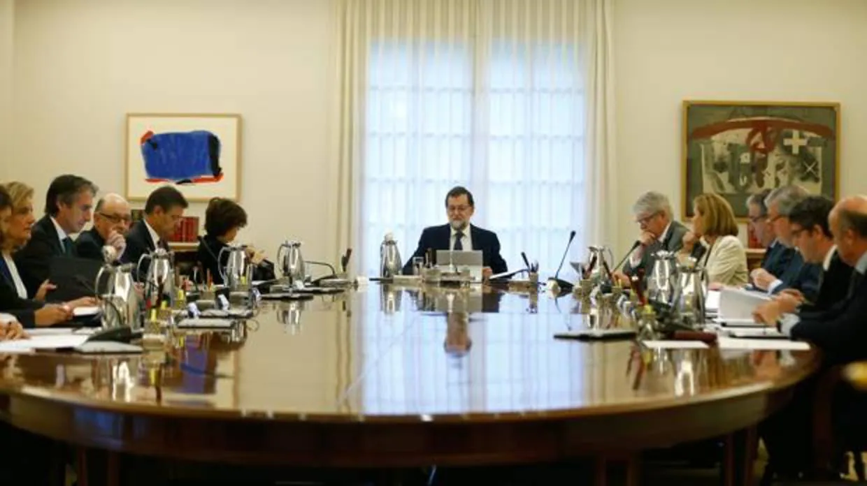 El presidente del Gobierno, Mariano Rajoy (c), junto a los ministros en La Moncloa