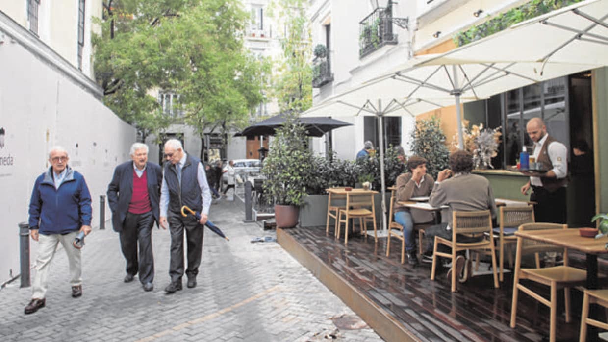 Tres hombres pasean junto a uno de los locales que se encuentra en el callejón de Puigcerdá