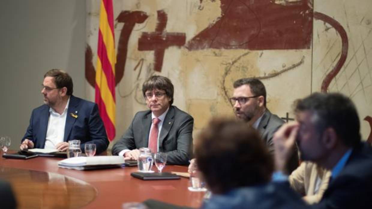 El presidente de la Generalitat, Carles Puigdemont (d) y el vicepresidente, Oriol Junqueras (i), durante la reunión semanal del gobierno catalán, a dos días de que el Parlament se reúna para acordar una respuesta a la aplicación del artículo 155 de la Constitución