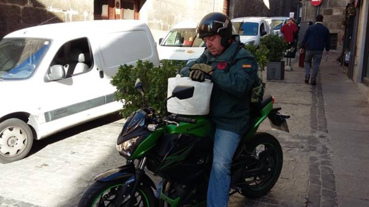 Hilera de coches de reparto y un motorista, parados en la calle de Sixto Ramón Parro, en el cruce con la del Cardenal Cisneros