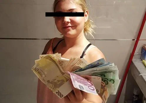 Una mujer, con un puñado de billetes robados