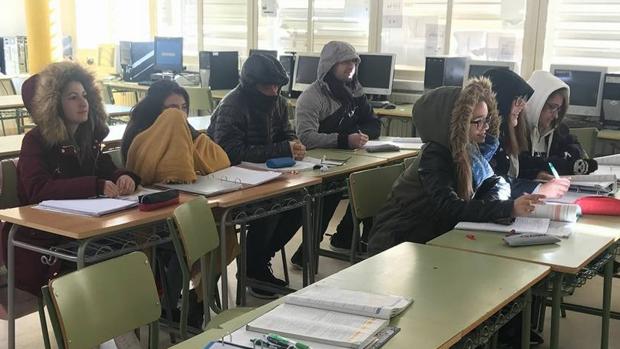 Con abrigos y capucha en las aulas por el frío