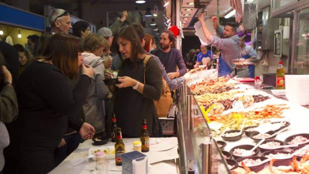Decenas de personas toman el aperitivo en una pescadería del Mercado de La Cebada