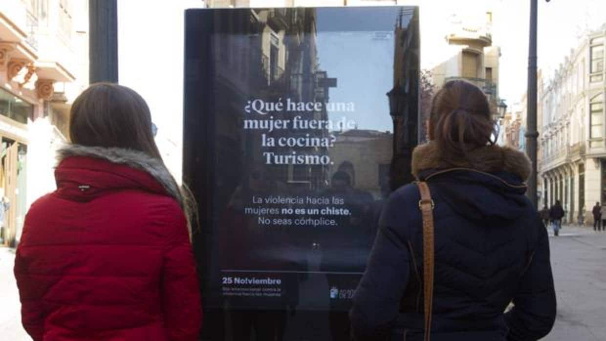 Dos jóvenes contemplan el cartel de la polémica campaña en las calles de Zamora