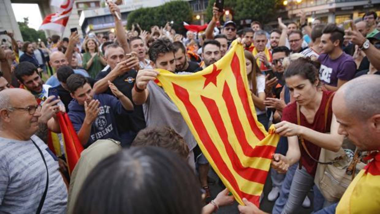 Un grupo de personas observa una bandera estelada en la manifestación del 9 de octubre en Valencia