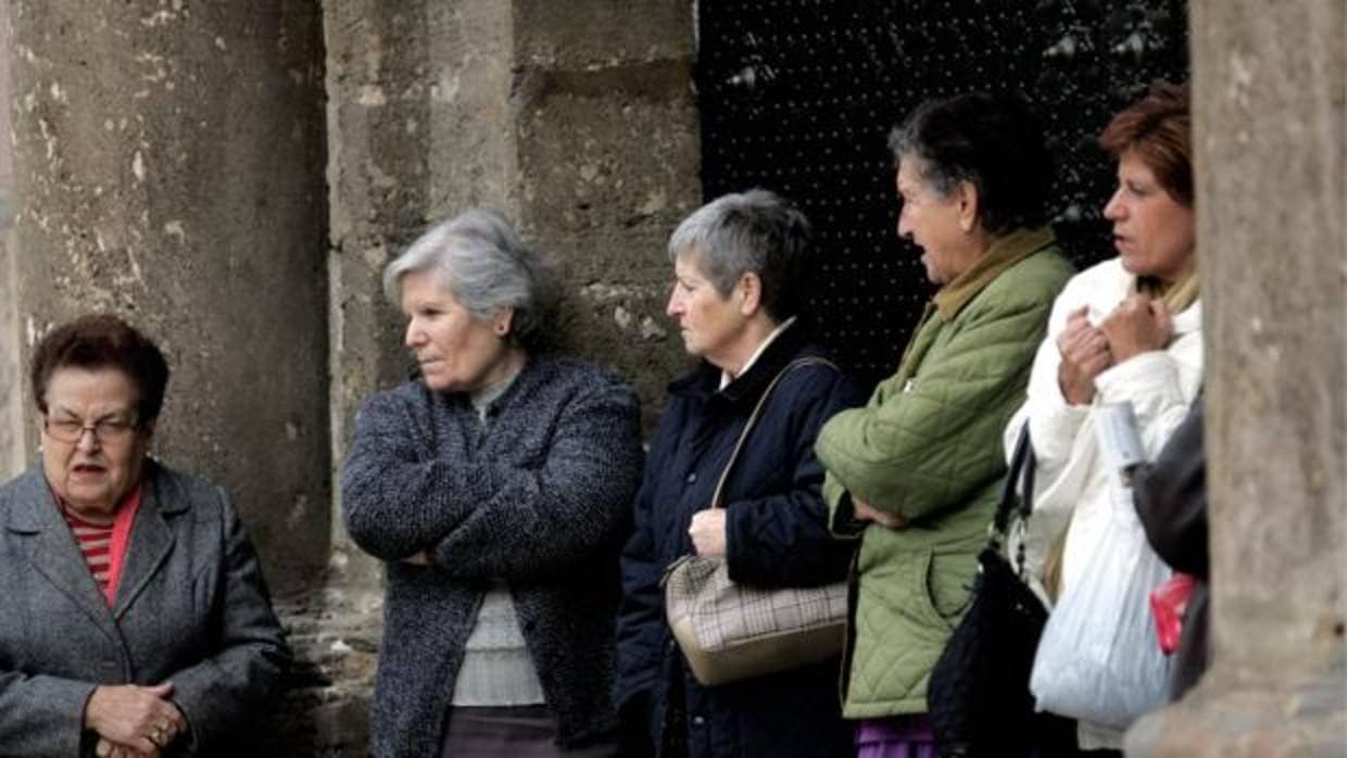 Varias mujeres de protegen del frío en el centro de Valencia