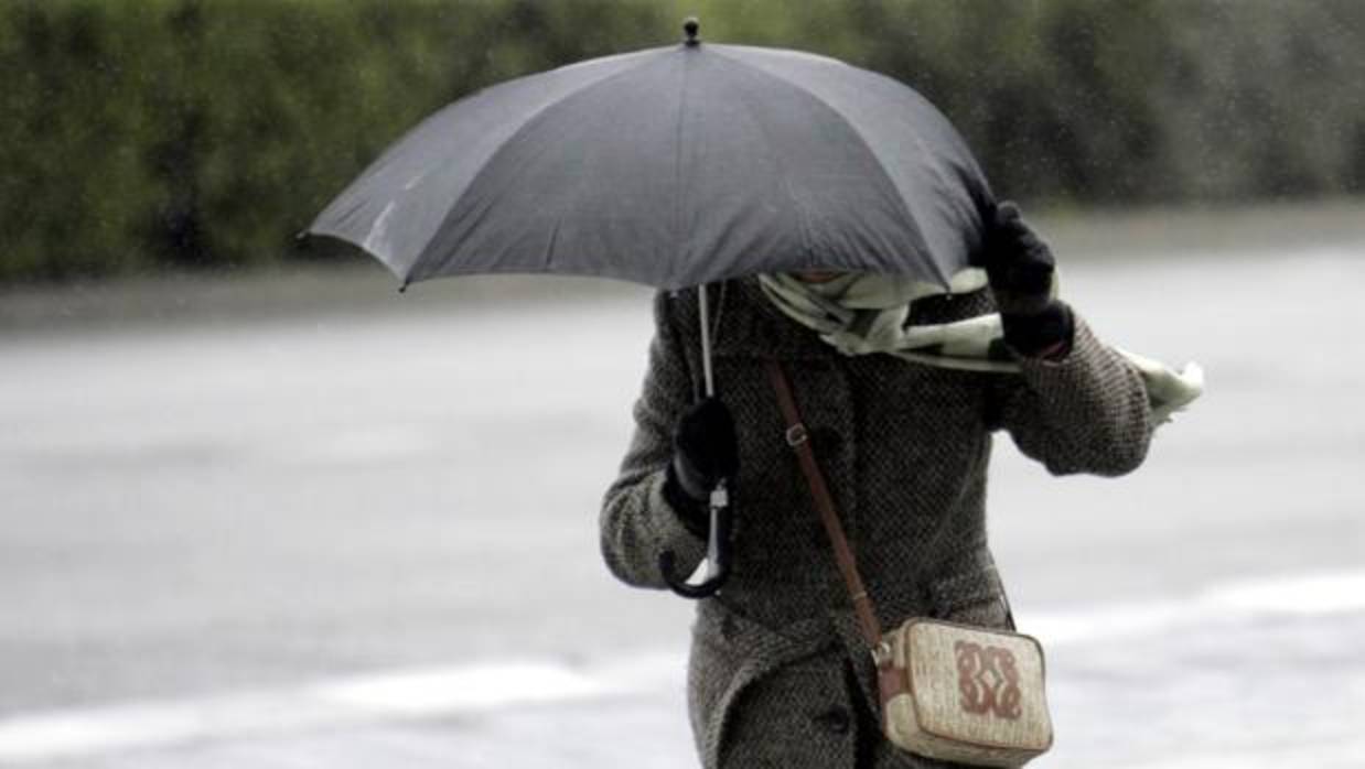 Una mujer se protege del viento y la lluvia, en una imagen de archivo