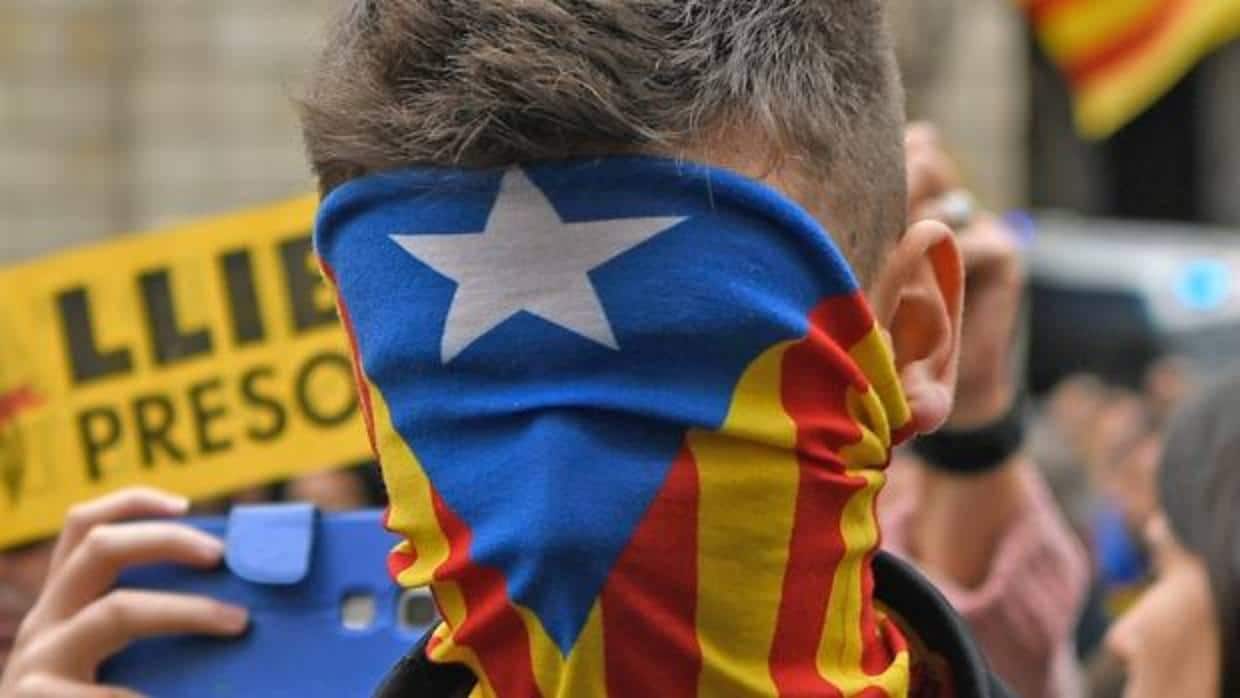 Un joven se tapa el rostro con una estelada durante una manifestación independentista en Barcelona