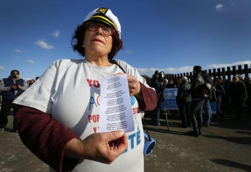 Una manfestante muestra un folleto con las reivindicaciones