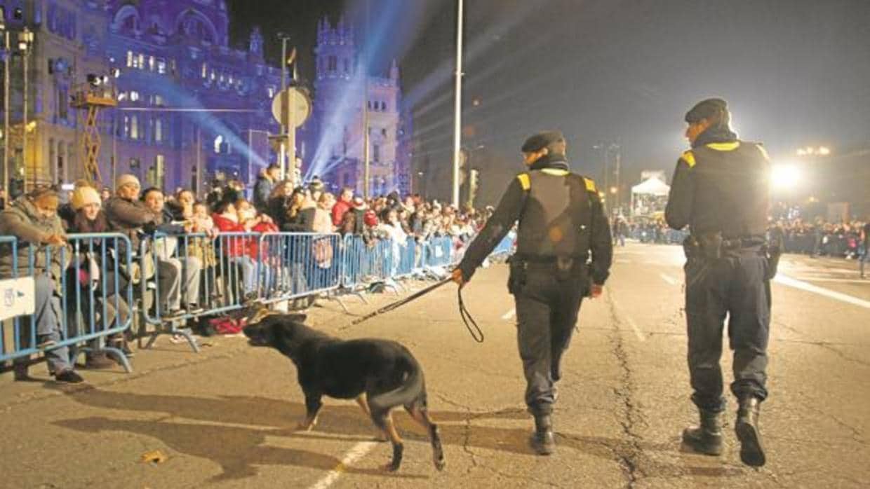 Dos policías municipales rastrean, con un perro especialista, la Cabalgata del año pasado