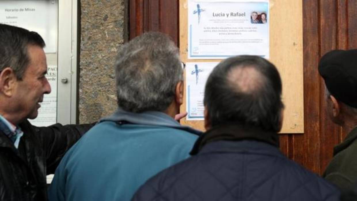 Vecinos de los fallecidos, observan la esquela de los dos ancianos asesinados en Bilbao