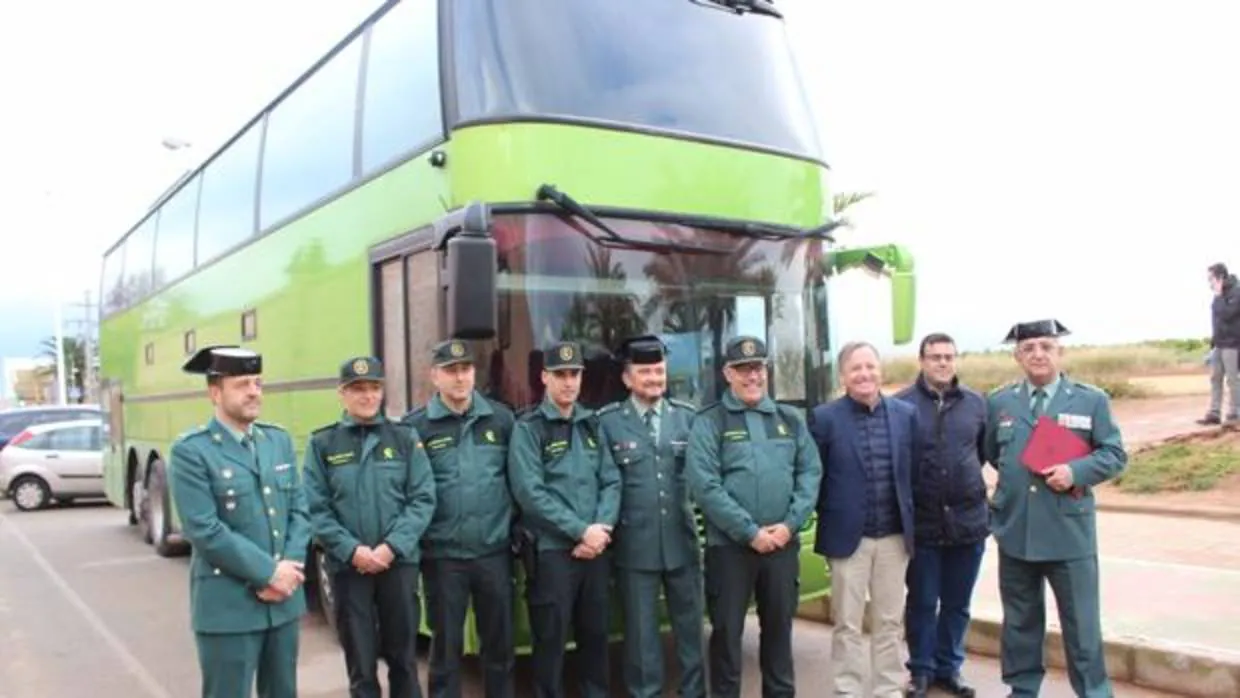 Mandos y autoridades posan ante el autobús en el que viajaban los detenidos