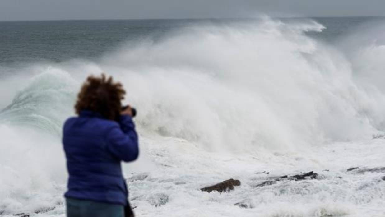 Una mujer fotografiando las olas en Ribadeo