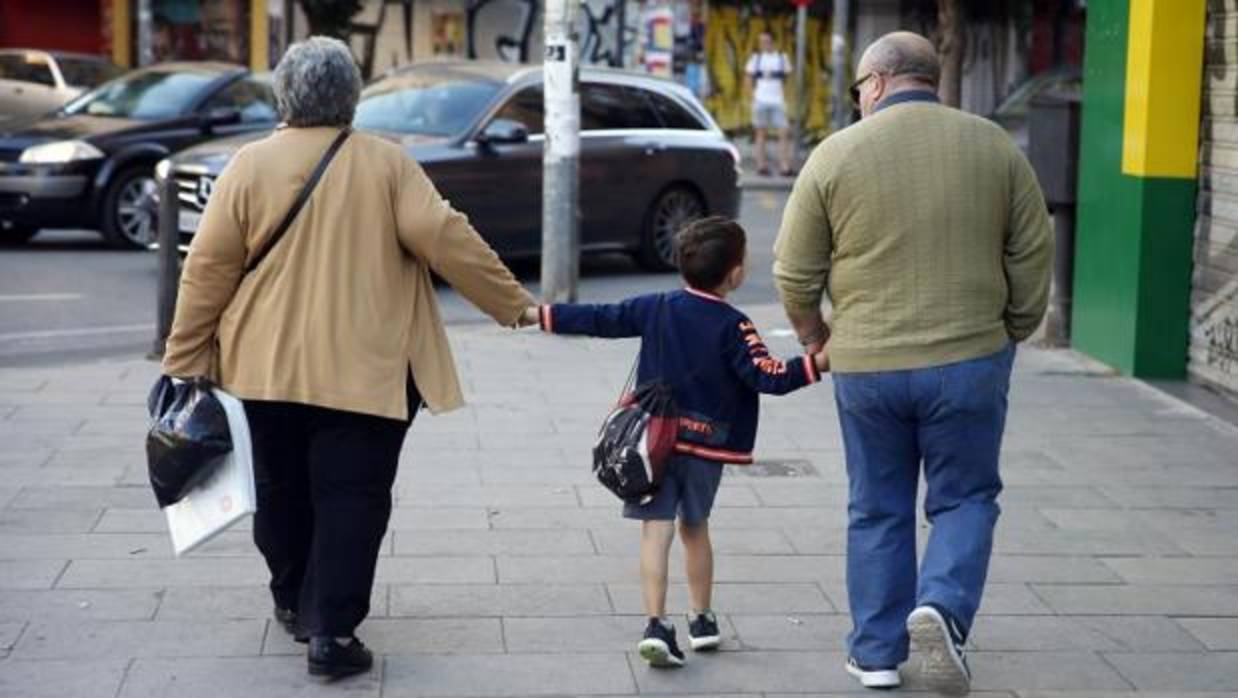 Dos abuelos acompañan a su nieto a la escuela