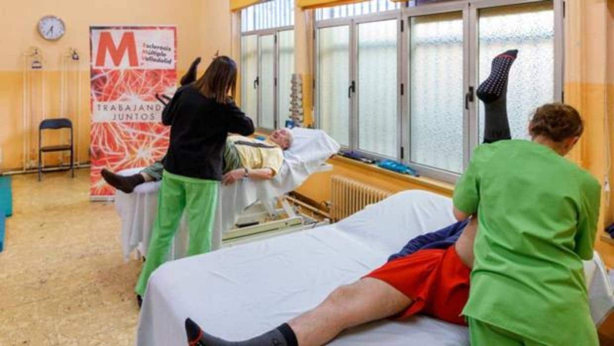 Dos fisioterapéutas de la Asociación Esclerosis Múltiple Valladolid durante una de las sesiones de rehabilitación que desarrollan en sus instalaciones