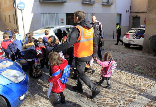 Un voluntario del Pedibús, en el colegio Divina Pastora, acompaña a los escolares para que sean recogidos en los vehículos