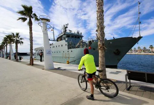 Un ciclista observa el patrullero Alborán atracado, este viernes, en Alicante