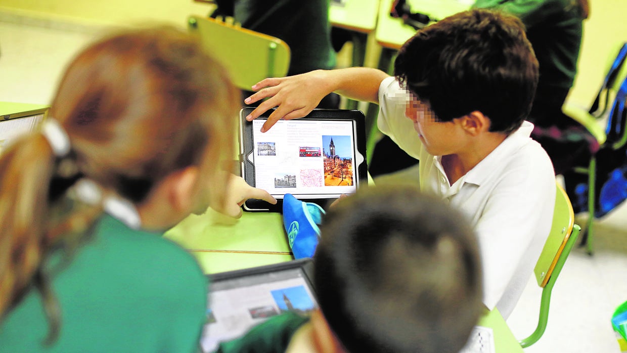 Un grupo de niños en clase estudian con tabletas