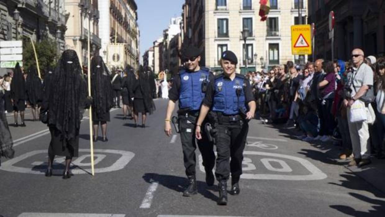 Dos agentes patrullan durante una procesión de Semana Santa