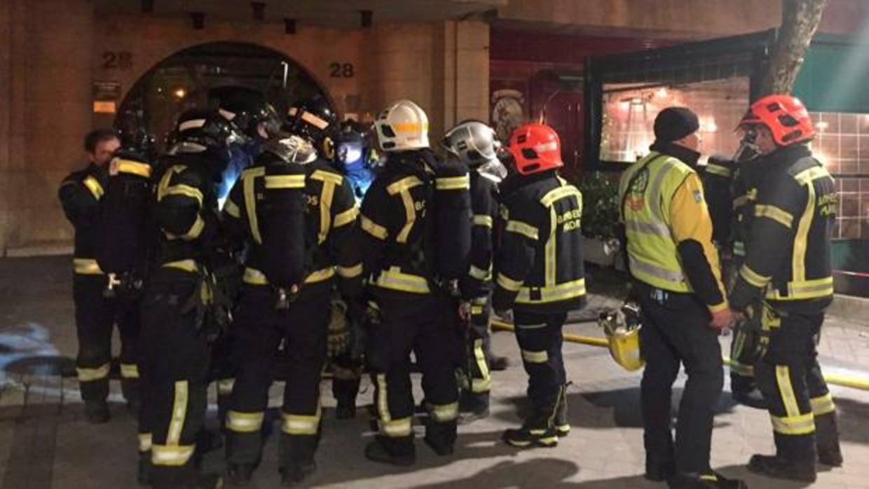 Los bomberos, a la entrada del edificio afectado por el fuego