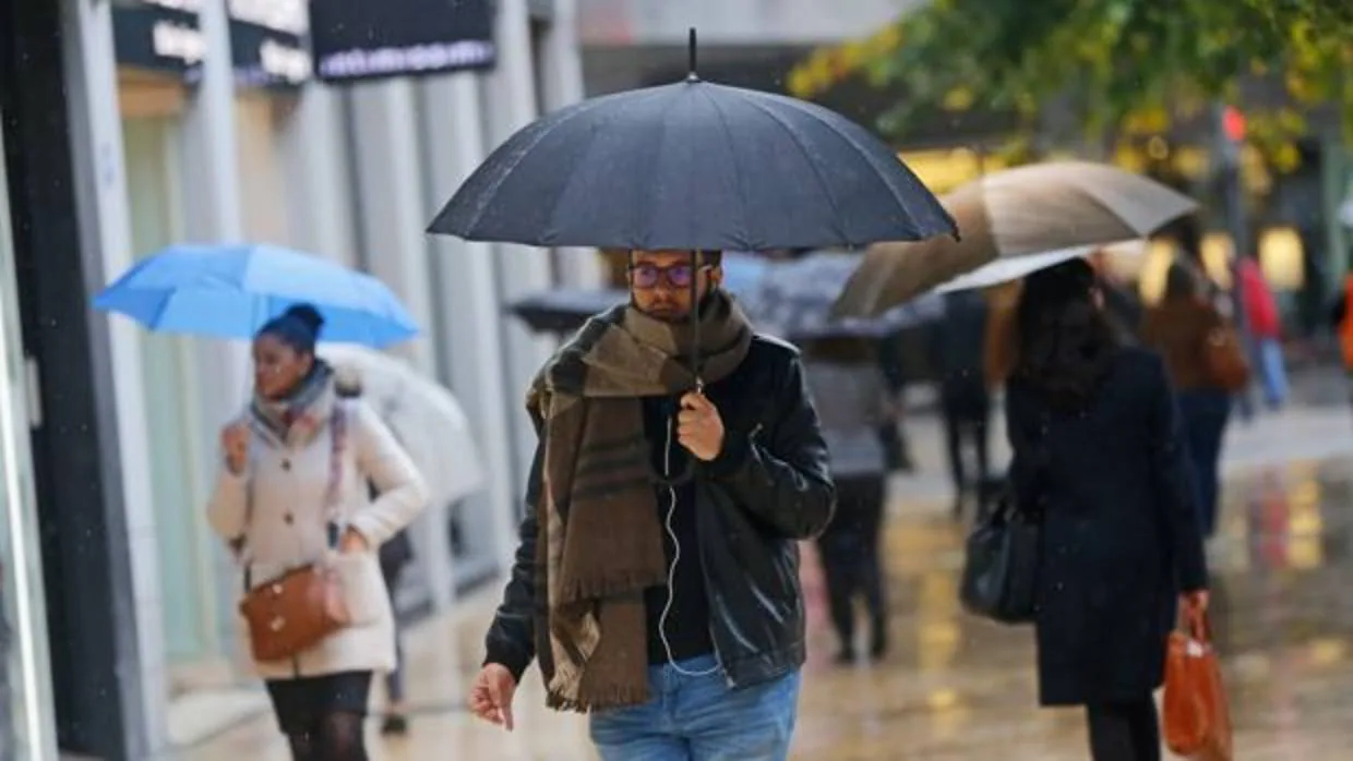 Varias personas se protegen de la lluvia en una imagen de archivo tomada en el centro de Valencia