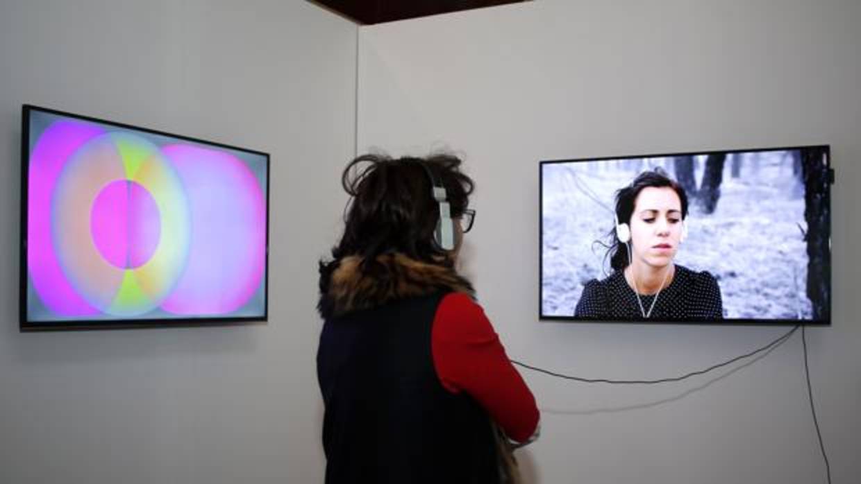 Una visitante observar una de las realizaciones de la muestra de videoarte