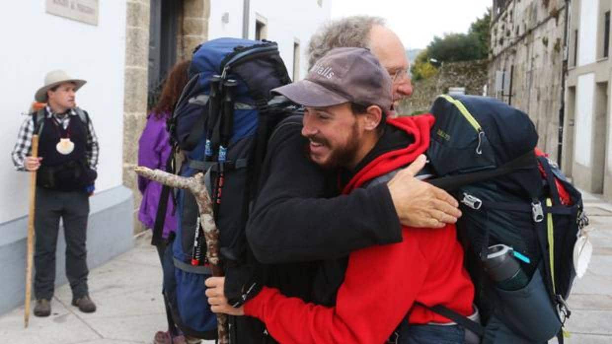 Dos peregrinos se abrazan a su llegada a Santiago