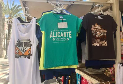 lLa camiseta con el castillo equivocado (derecha) junto a otras a la venta en la Explanada de Alicante