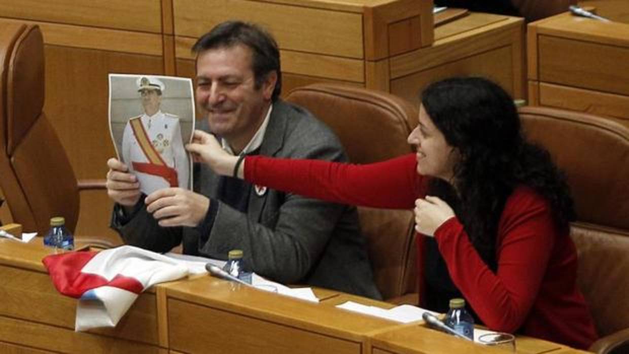 Luis Bará muestra desde su escaño la foto que posteriormente acabó rompiendo en la tribuna del Parlamento