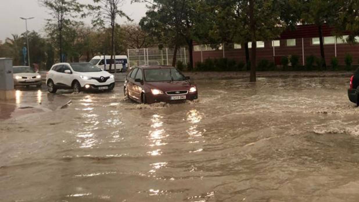 Varios coches circulando con dificultades este viernes durante la fuerte tormenta en Alicante