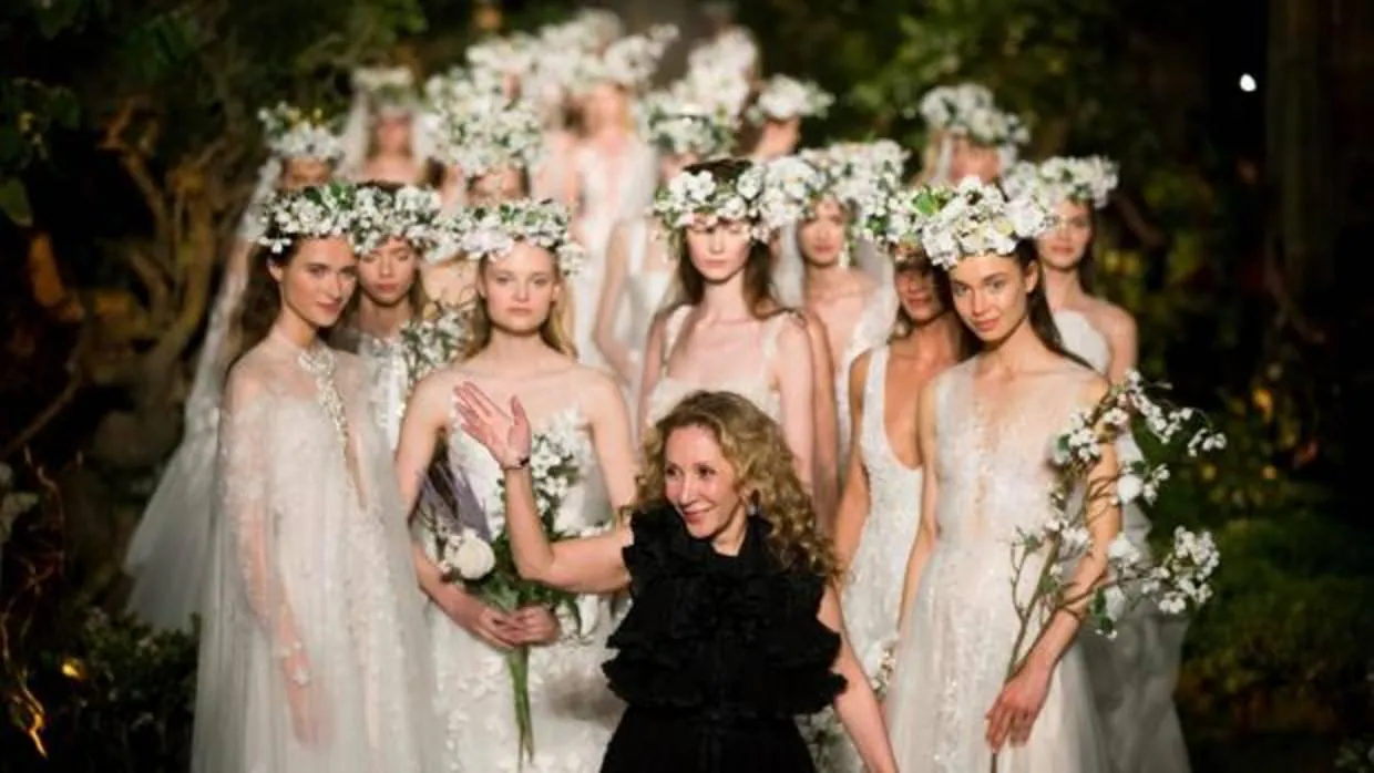 La diseñadora libanesa Reem Acra, junto a sus modelos, saluda tras el pase de sus vestidos