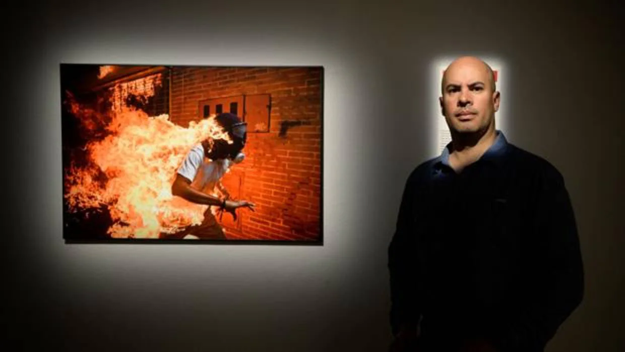 El fotógrafo venezolano Ronaldo Schemidt, junto a la imagen ganadora del World Press Photo