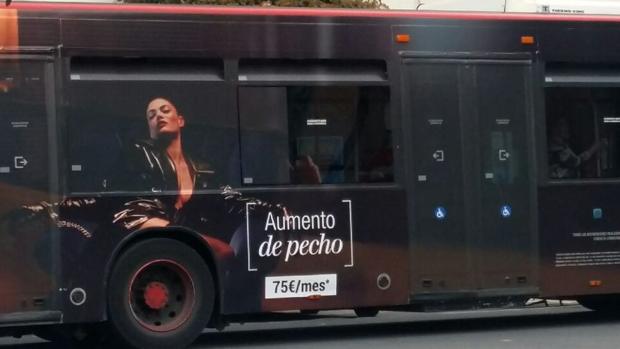 Una mujer esposada para anunciar un aumento de pecho en la publicidad del autobús público de Valencia