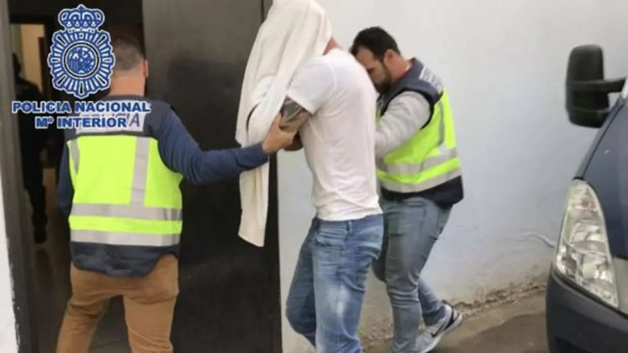 El detenido, acompañado por dos agentes a la entrada de las dependencias policiales de Marbella