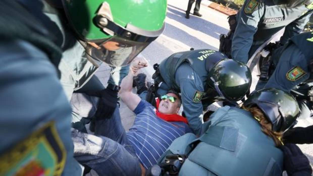 Efectivos de la Guardia Civil desalojan a un funcionario durante la protesta