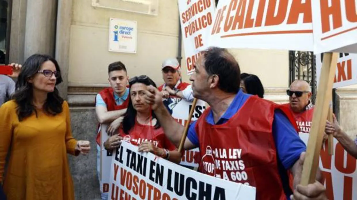Oltra conversa con un grupo de taxistas que protestaban este viernes frente al Palau de Castellfort