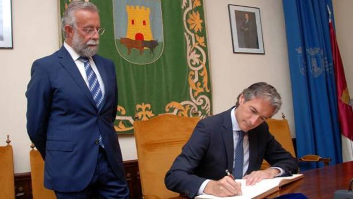 El ministro de Fomento, Íñigo de la Serna, firma en el libro de honor de Talavera de la Reina en presencia del alcalde, Jaime Ramos, el 13 de julio de 2017