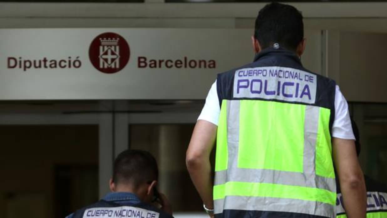 Varios policías se dirigen hacia la entrada de la sede de la Diputación de Barcelona, ayer durante la operación Estela