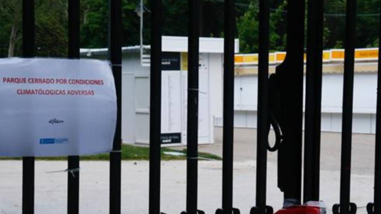 Las casetas de la Feria del Libro en El Retiro, tras un cartel que advierte del cierre