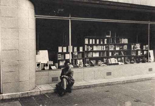 Gregorio Prieto sentado ante una librería donde se expone su libro «Students»