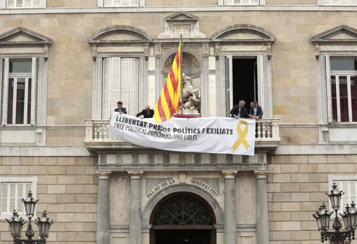 Trabajadores de la Generalitat cuelgan en el balcón del Palau de la Generalitat, una pancarta a favor de la libertad de los presos políticos