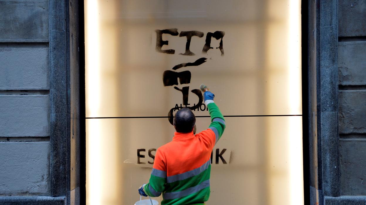 Un operario borra una pintada con el anagrama de la banda terrorista ETA