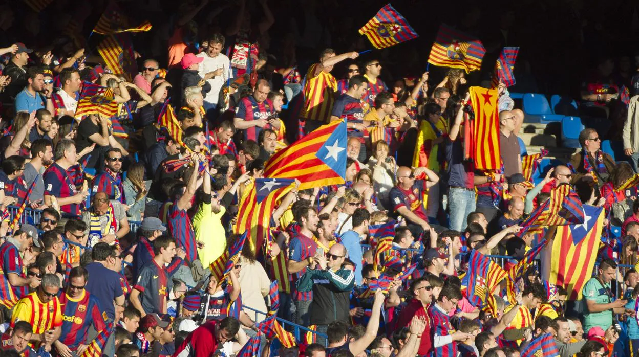 Aficionados del Fútbol Club Barcelona portando esteladas en el partido contra el Sevilla